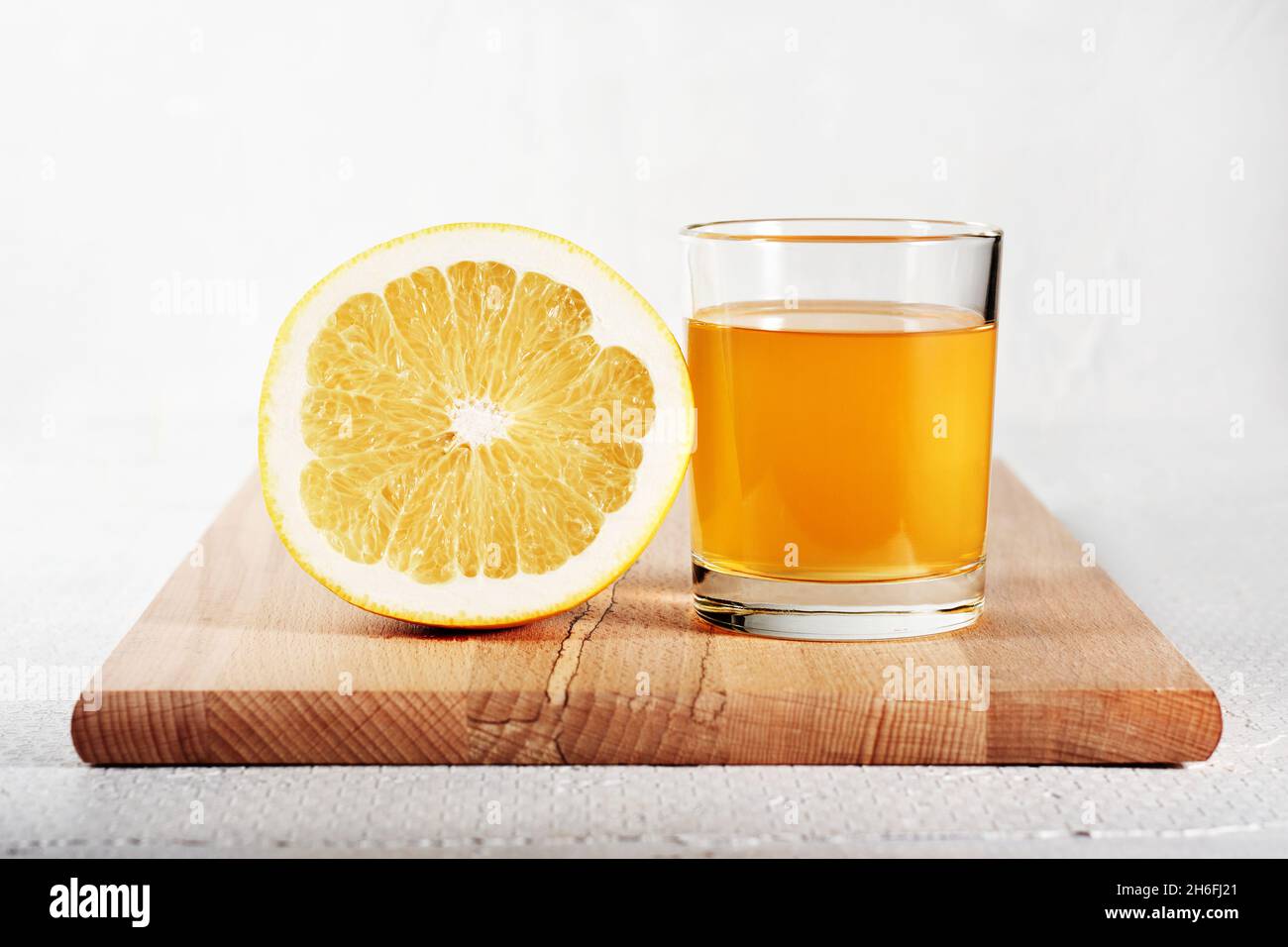 Fresh grapefruit juice in a glass and half a grapefruit. Stock Photo