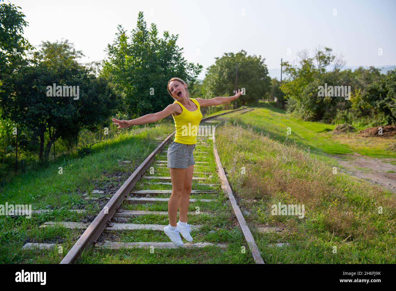 slender girl jumping on the railroad tracks Stock Photo Alamy
