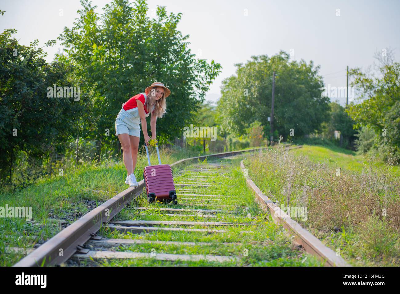 a girl dragging a very heavy suitcase on the sleepers Stock Photo Alamy