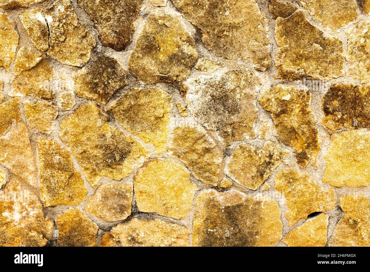 Background of dark yellow brown rough stone wall texture horizon Stock