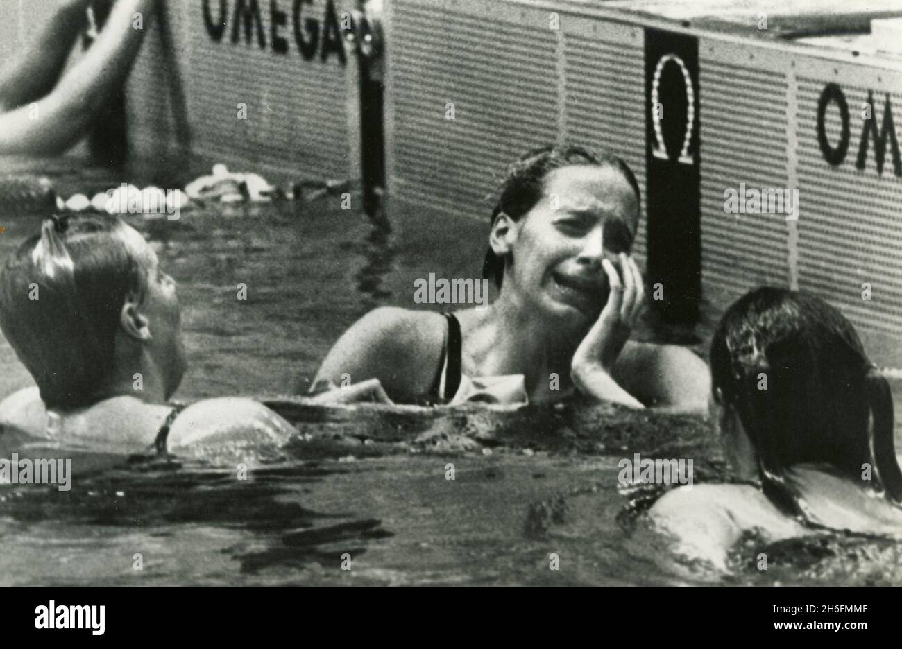 American swimmer athlete Kaye Hall (center) weeps after having won the