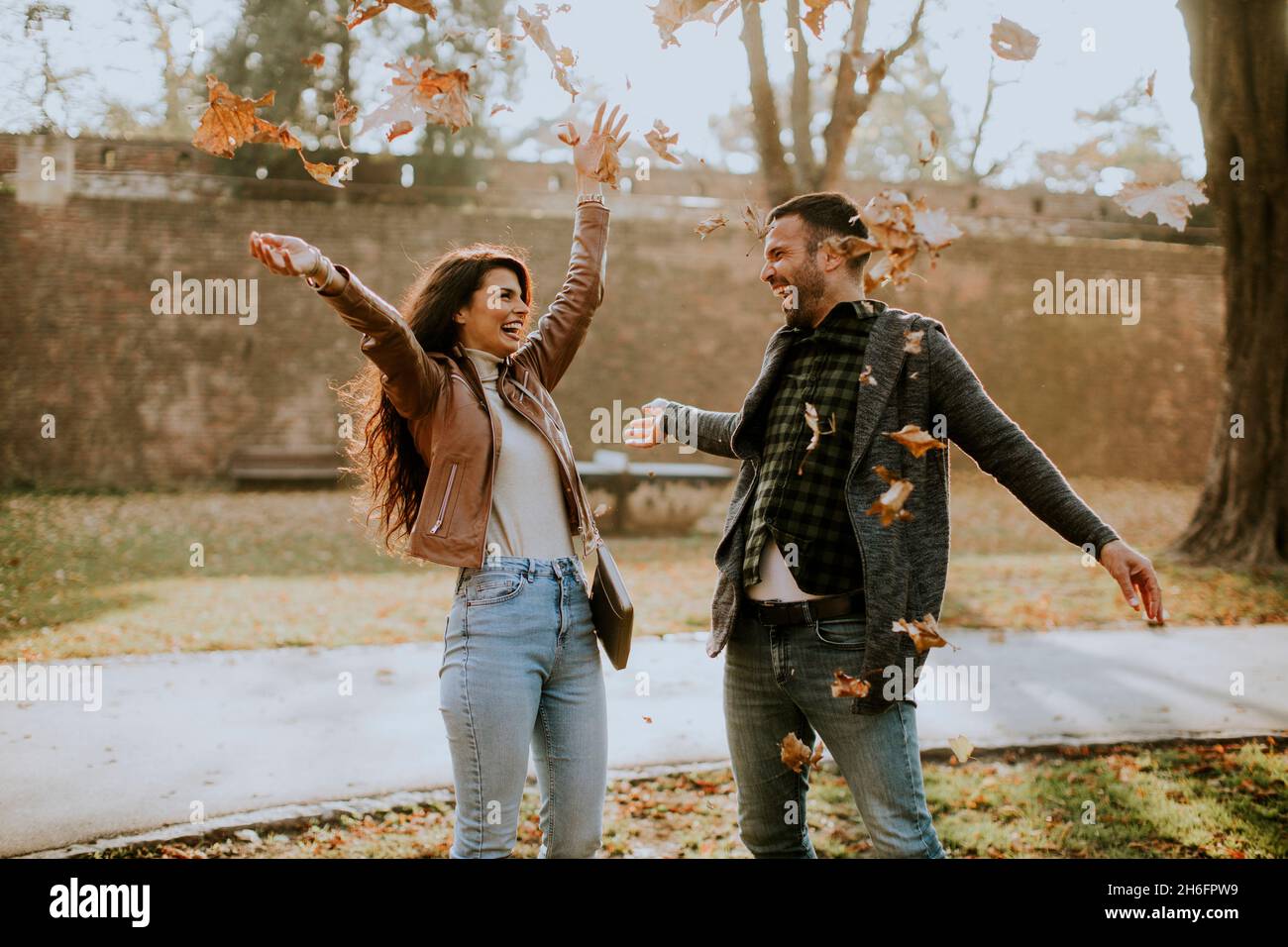 Happy young couple having fun with autumn leaves in the park Stock ...