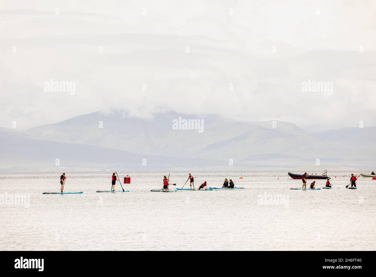 Stand up surfers on SUP boards offshore at Old Head beach, Louisburgh, County Mayo, Ireland Stock Photo