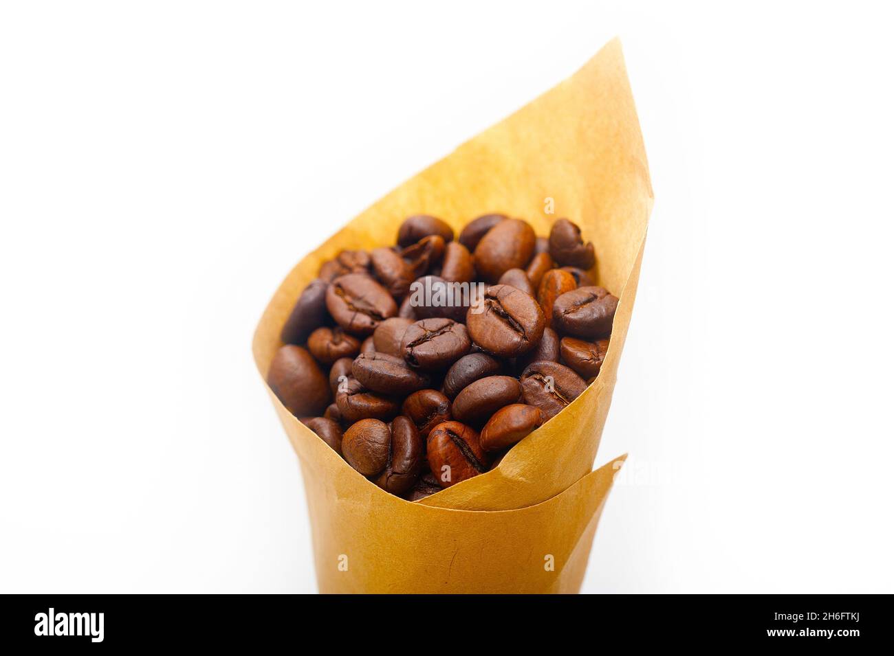 espresso coffee beans on a paper cone cornucopia over white background Stock Photo