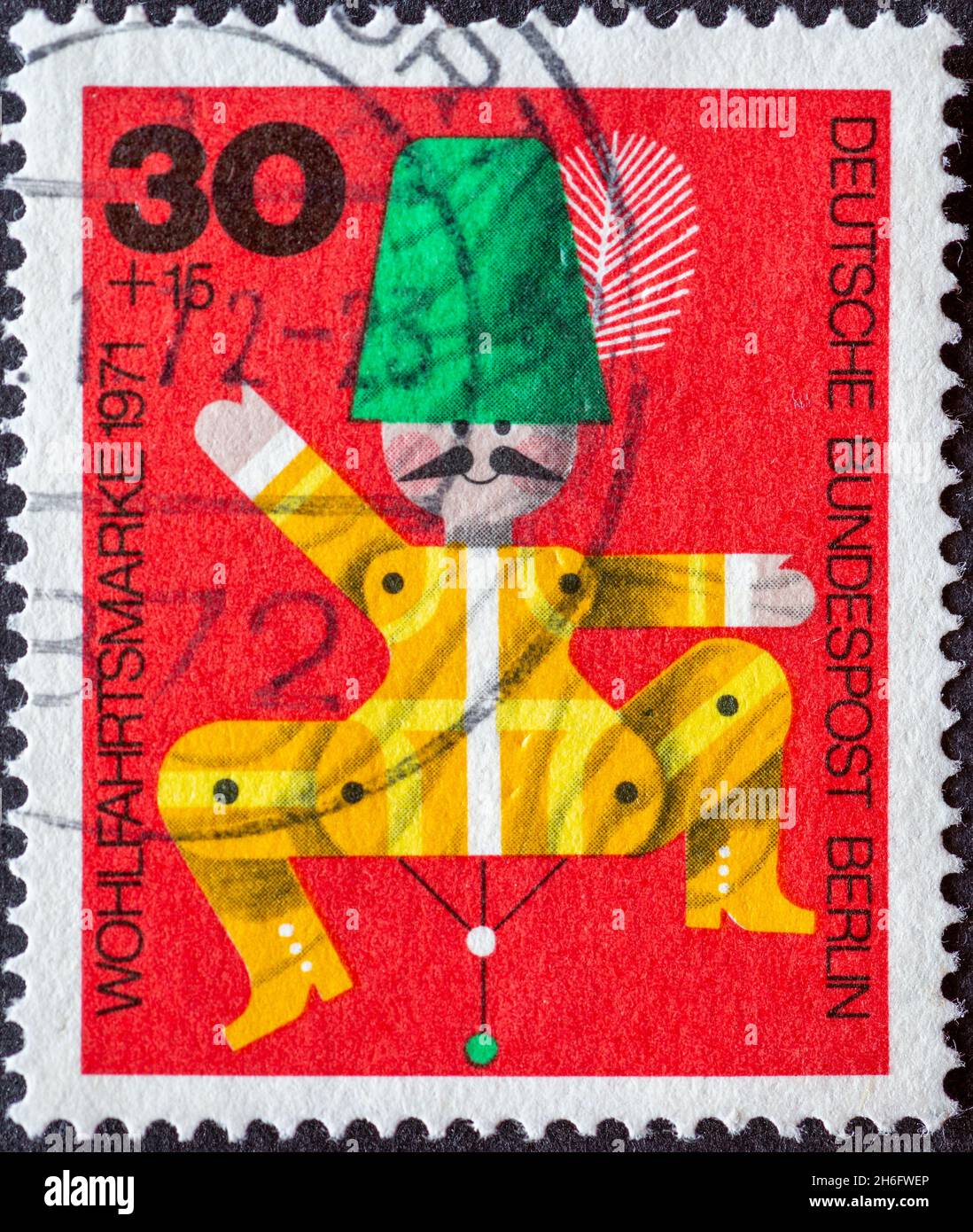 GERMANY, Berlin - CIRCA 1971: a postage stamp from Germany, Berlin showing a 1971 charity postal stamp with old wooden toys. Here: Hampel or Zappelman Stock Photo