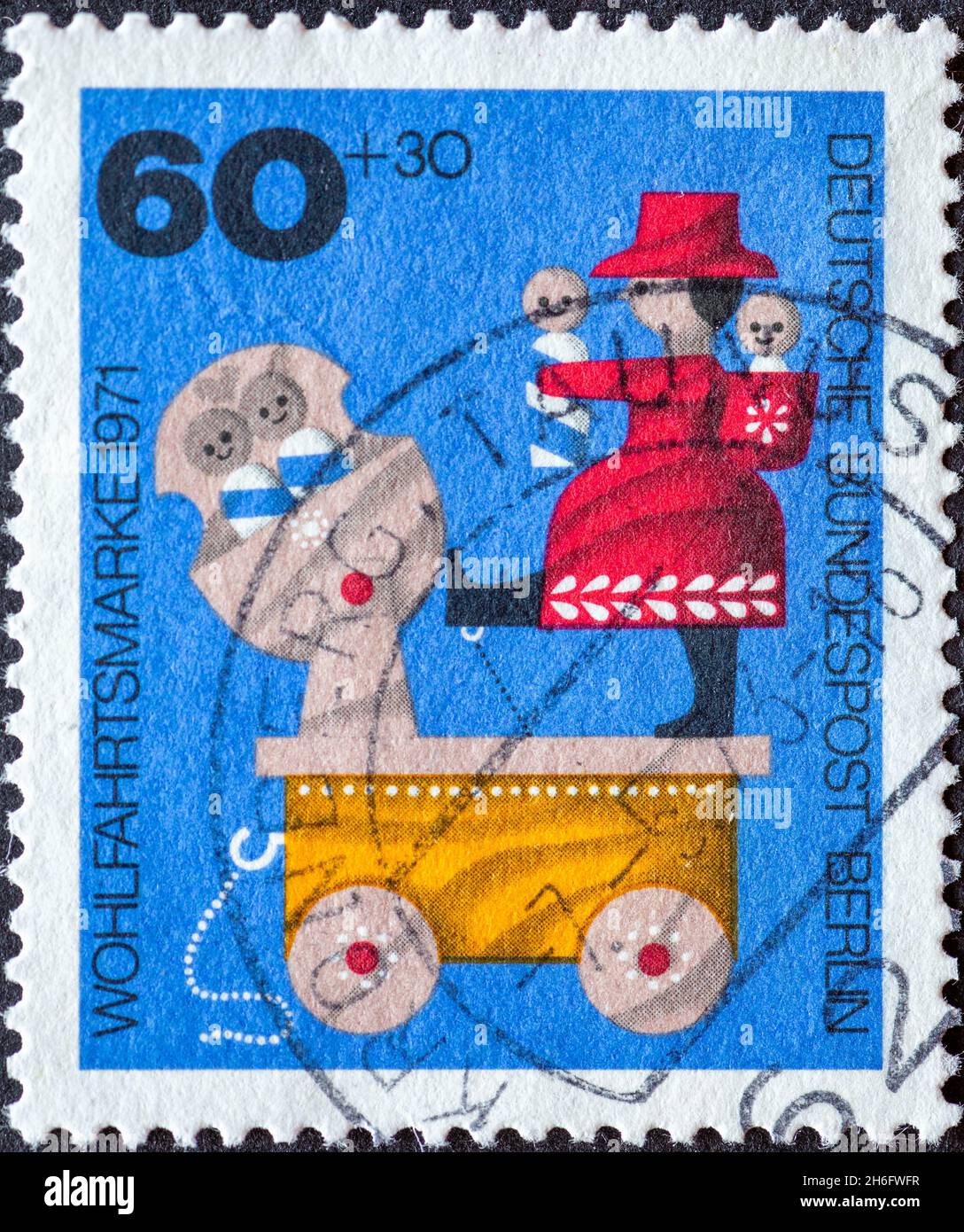 GERMANY, Berlin - CIRCA 1971: a postage stamp from Germany, Berlin showing a 1971 charity postal stamp with old wooden toys. Here:  Mobile swing swing Stock Photo