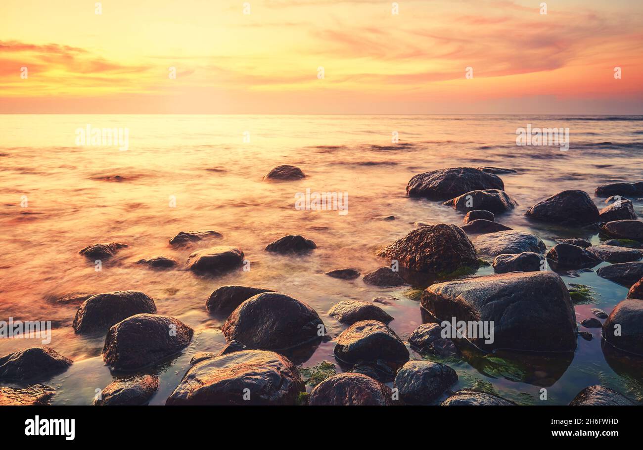 Rocky beach at a beautiful sunset, color toning applied. Stock Photo