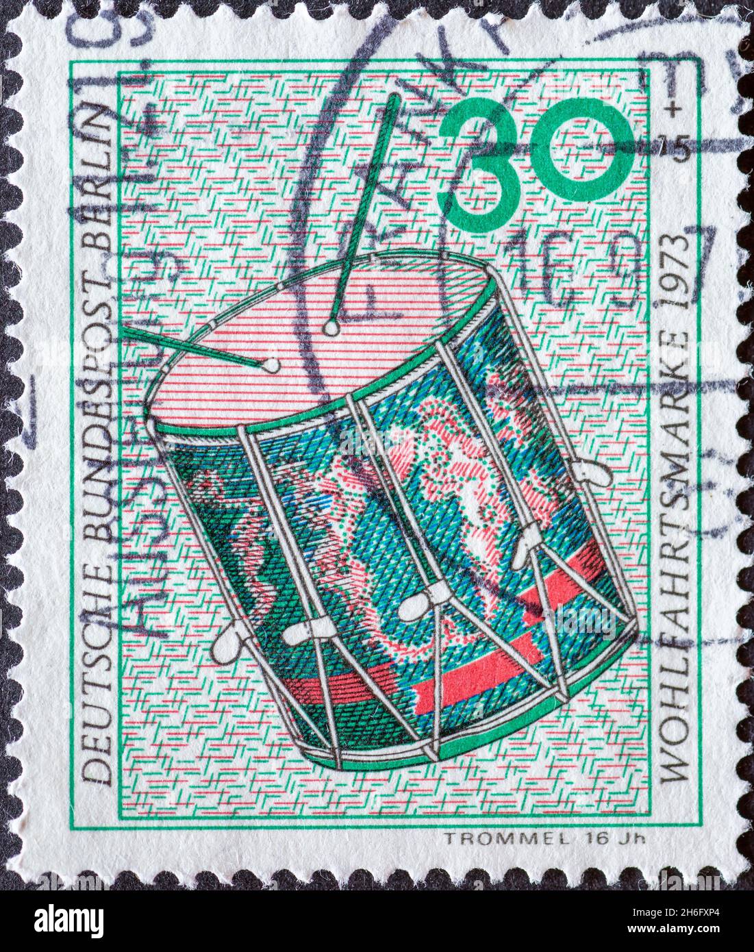 GERMANY, Berlin - CIRCA 1973: a postage stamp from Germany, Berlin showing a charity postal stamp from 1973 musical instruments. Here drum Stock Photo