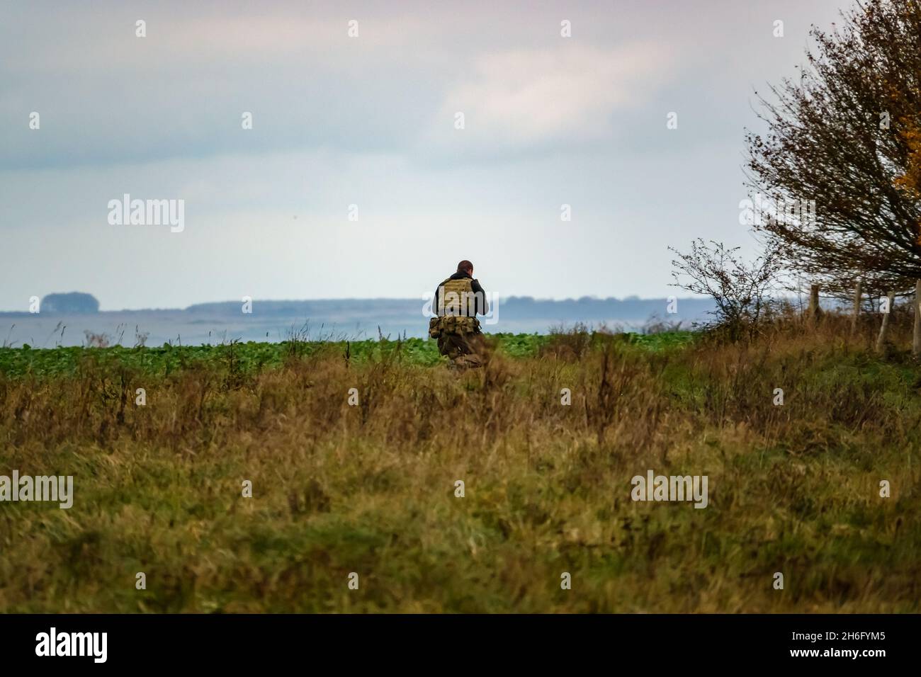 British army special forces soldier with SA80 L85 rifle at the ready runs towards enemy located in woodland, on a military exercise, Wiltshire UK Stock Photo