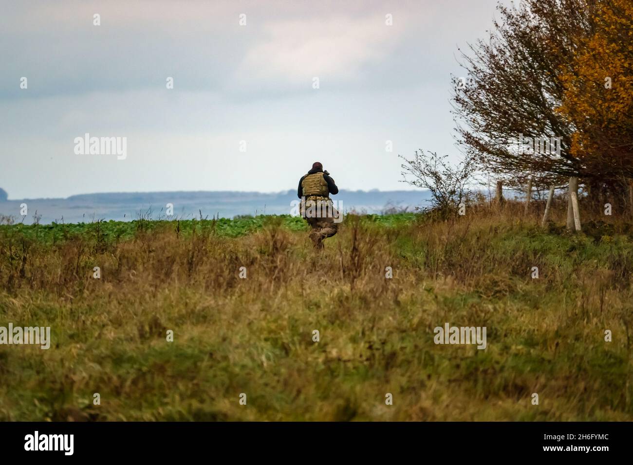 British army special forces soldier with SA80 L85 rifle at the ready runs towards enemy located in woodland, on a military exercise, Wiltshire UK Stock Photo