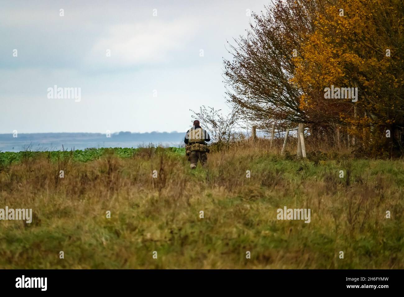 British army special forces soldier with SA80 L85 rifle at the ready runs towards enemy located in woodland, on a military exercise, Wiltshire UK Stock Photo