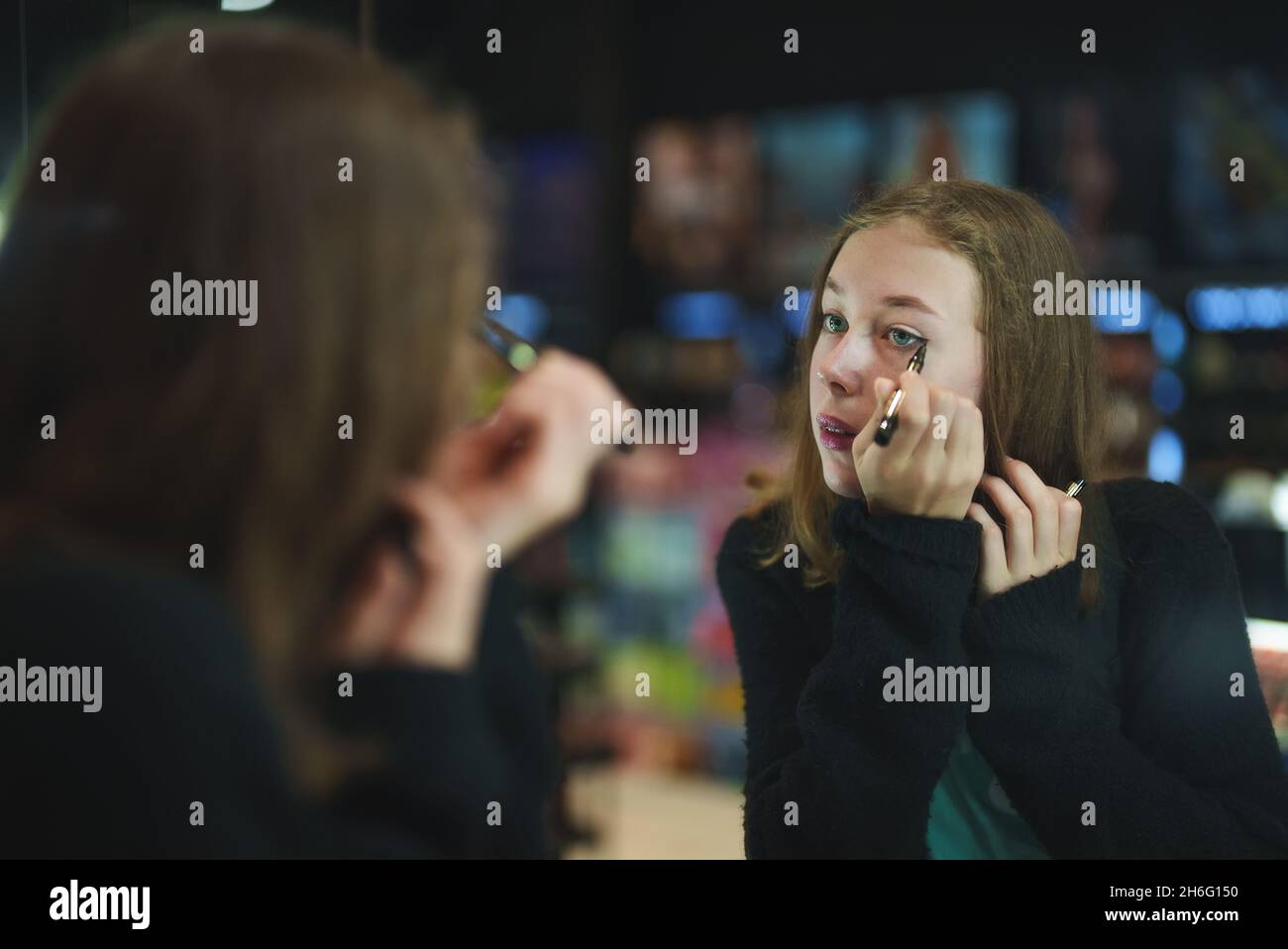 Teenage girl trying cosmetics products in the cosmetics store. Doing ...