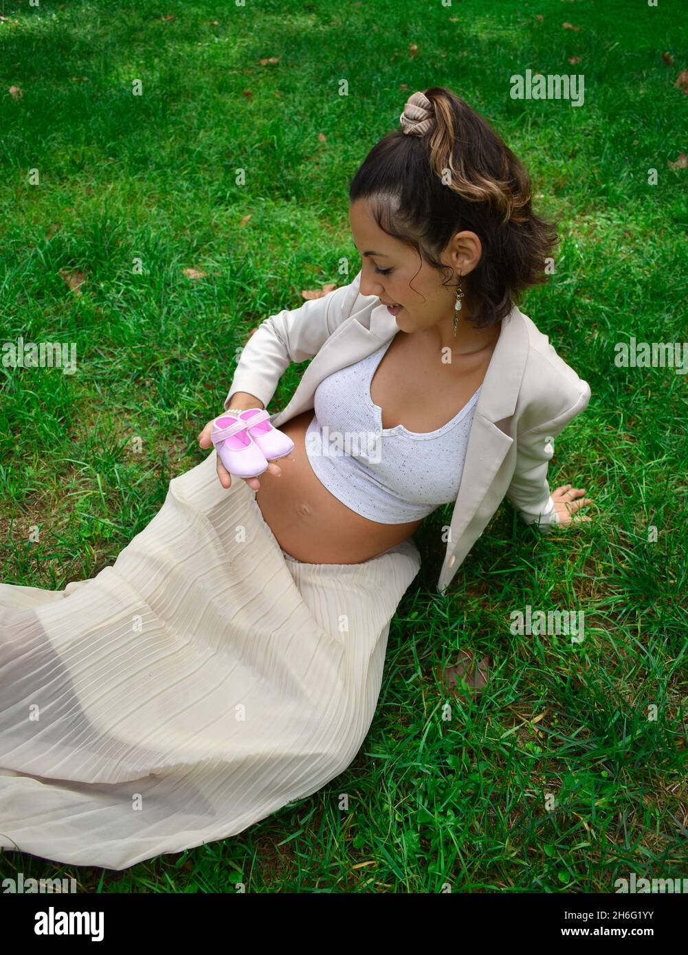 Pretty Young Caucasian Pregnant Woman In White Clothes Posing In A Park