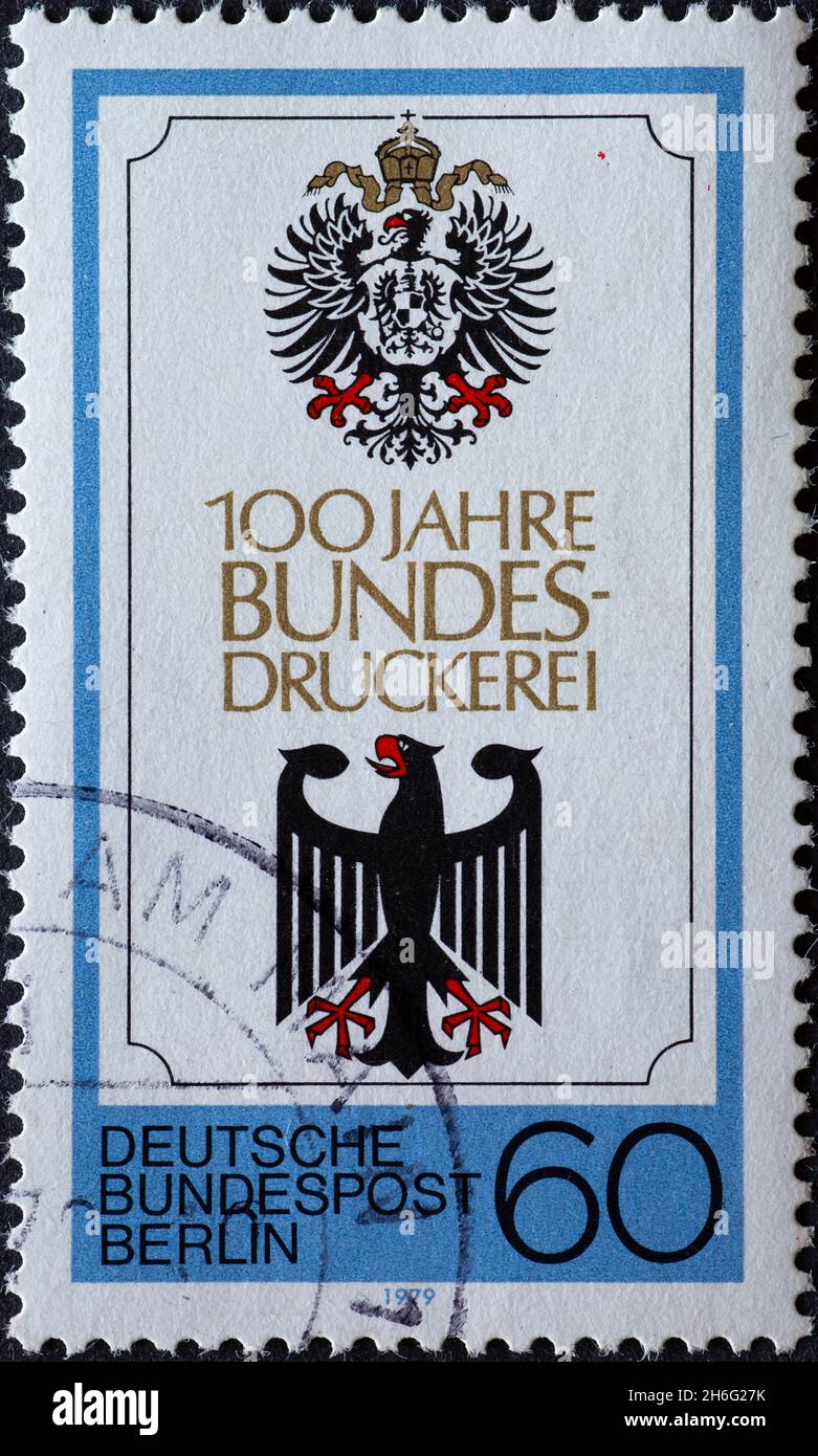 GERMANY, Berlin - CIRCA 1979: a postage stamp from Germany, Berlin showing Reichsadler and Bundesadler. Text: 100 years of Bundesdruckerei Berlin Stock Photo