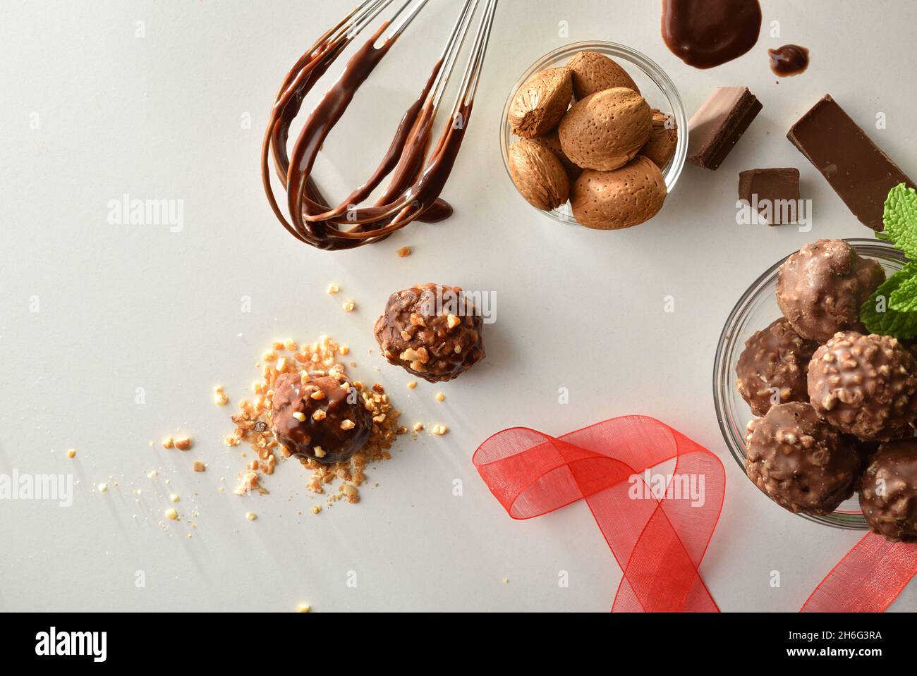 Preparing chocolate balls with almond chips on a white bench with kitchen tools. Top view. Horizontal composition. Stock Photo