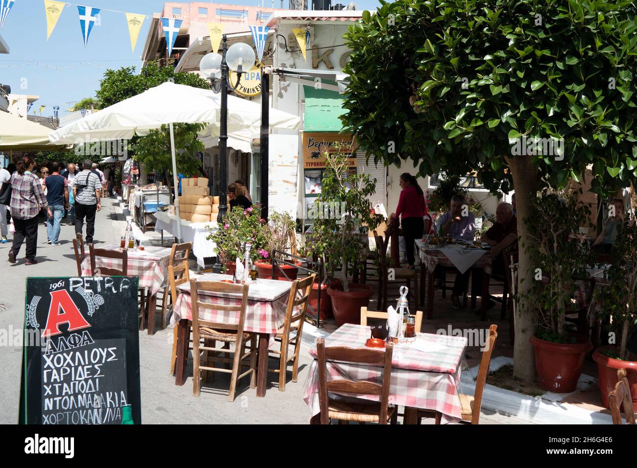 Kissamos, Crete - Greece - April 29 2016 :  Pavement taverna in a busy square in this bustling Greek town  Easter celebrations with people enjoying th Stock Photo