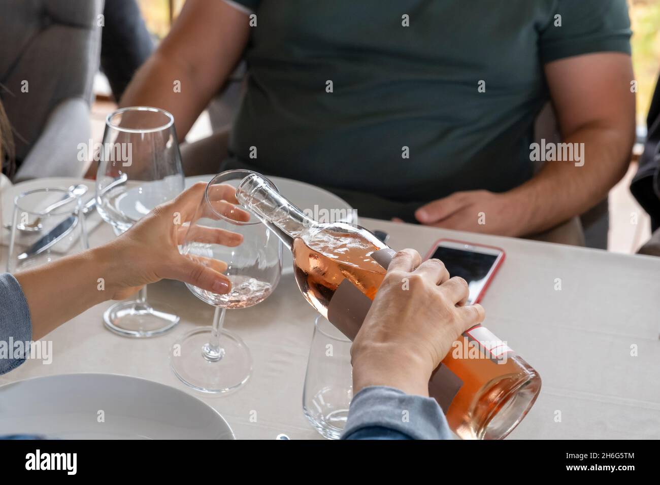 hand filling wine glass at dinner Stock Photo