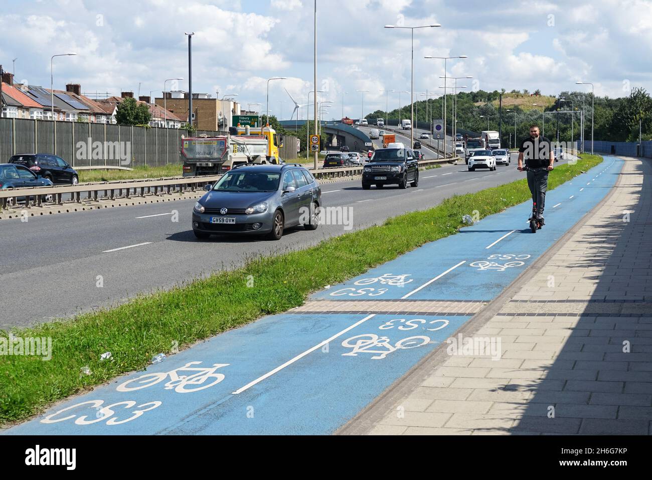 Man on e-scooter on Cycle Superhighway 3, Cycleway 3, on A13 Newham Way road, London, England, United Kingdom, UK Stock Photo