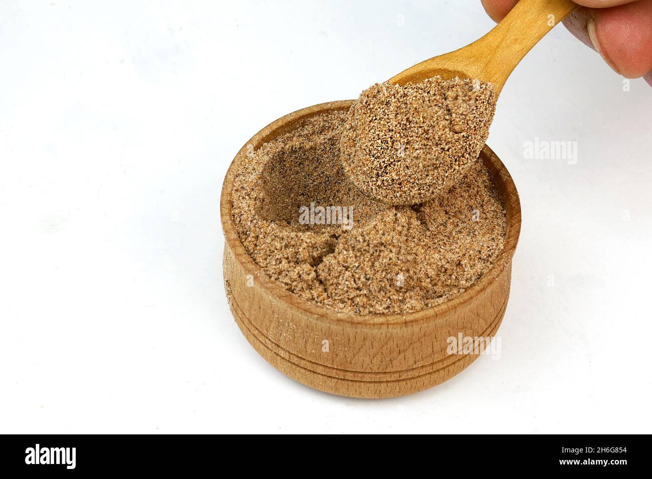 Chef taking chopped dry nutmeg powder spices from wooden spice jar. Close-up. Selective focus. Close-up. Stock Photo