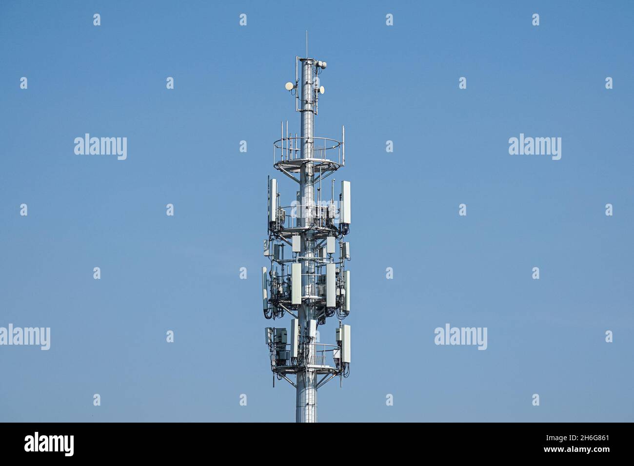 Cell phone, mobile phone telecommunication tower with antennas on blue sky Stock Photo