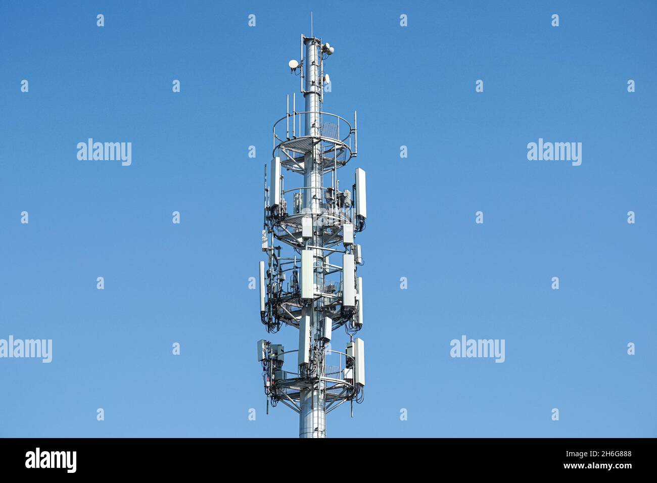 Cell phone, mobile phone telecommunication tower with antennas on blue sky Stock Photo
