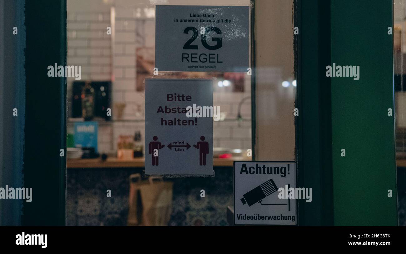 Berlin, Germany. 15th Nov, 2021. '2G' is written in capital letters on the notice on the entrance door of a shop on Simon-Dach-Strasse. As of today, the 2G rule is in effect in Berlin. In view of the increased number of infections in Berlin, the 2G rule has been in effect in many places since Monday. People who have not been vaccinated against the coronavirus, or who are recovering, are thus denied access to hairdressers, restaurants, museums or cinemas, for example. Credit: Paul Zinken/dpa/Alamy Live News Stock Photo