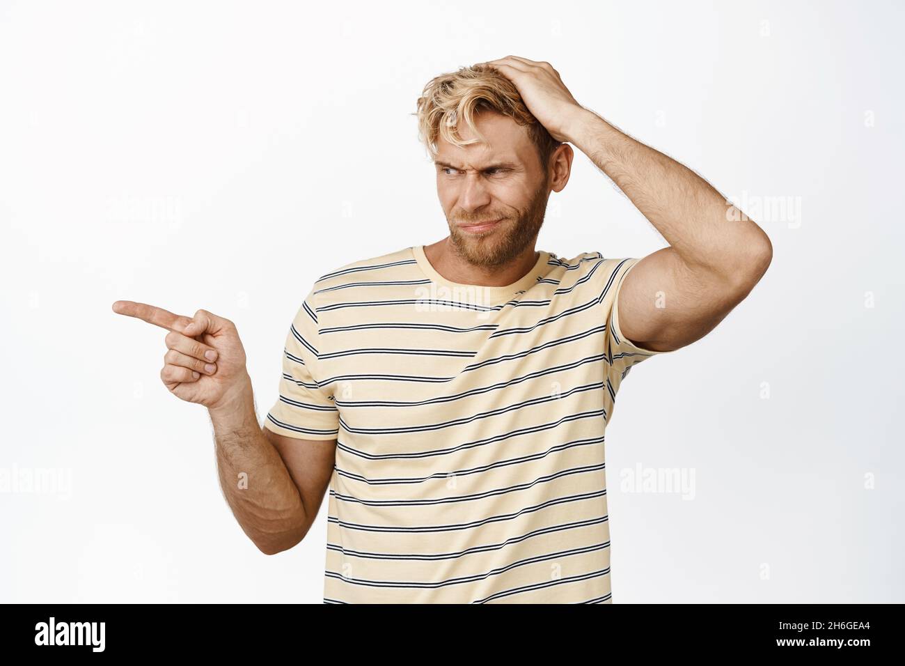 Something Repulsive Portrait of displeased blond man pointing and looking left, showing ...