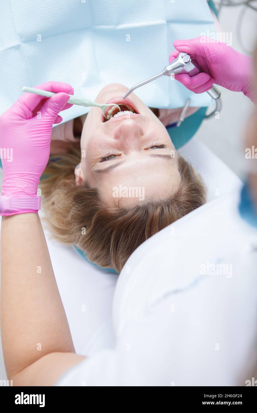 Vertical top view shot of a mature woman getting dental treatment by professional dentist Stock Photo