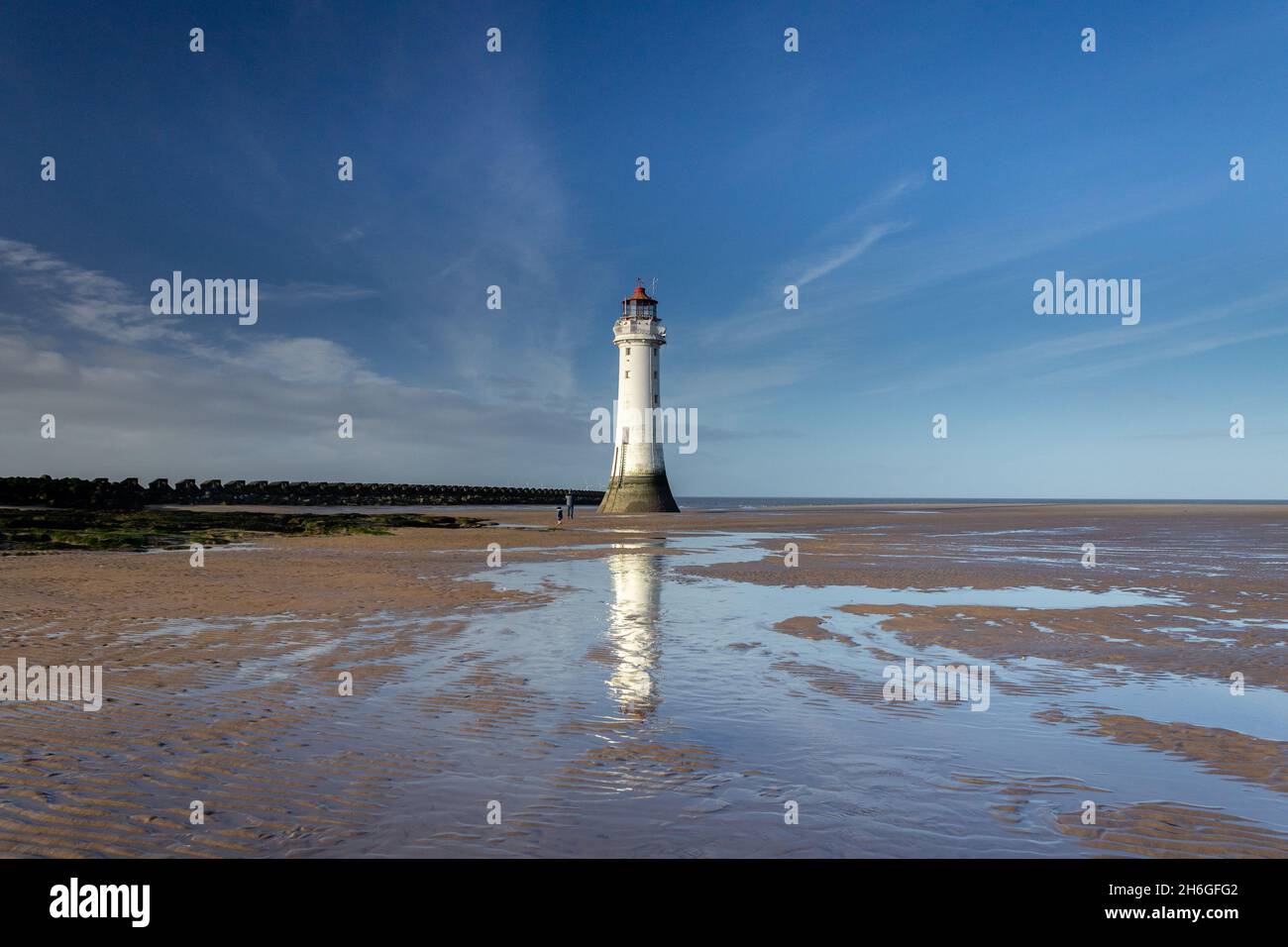 New Brighton, UK: Perch Rock lighthouse and groyne sea defence at low tide, North Wirral coast. Stock Photo