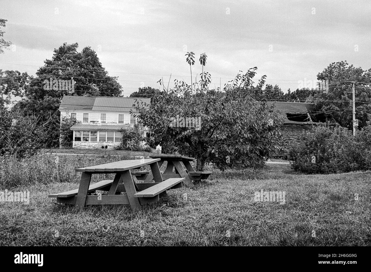 Picnic tables accross from ababonded home and barn Elwood Orchards - Londonderry, NH - Captured on Ilford XP2 black and white film. Stock Photo