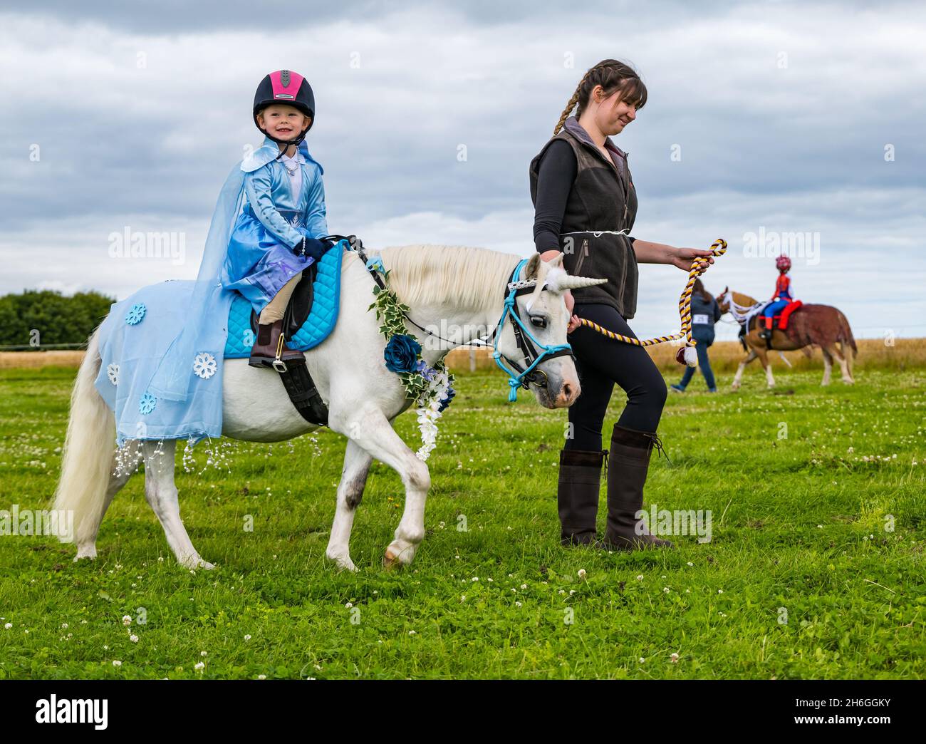 Summer horse show: a child on a pony dressed as a unicorn in a fancy dress competition, East Lothian, Scotland, UK Stock Photo