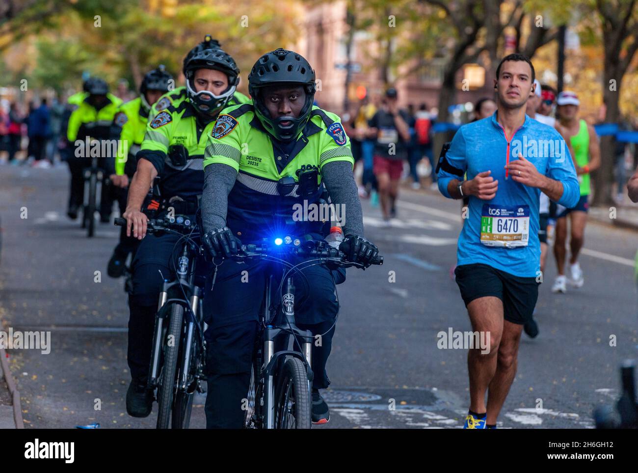 A phalanx of NYPD officers on bicycles in Harlem in New York near the 22 mile mark near Mount Morris Park on Sunday, November 7, 2019 in the 50th running of the TCS New York City Marathon. About 30,000 runners. down from the usual 50,000, participated in the race which was cancelled last year due to the pandemic.  (© Richard B. Levine) Stock Photo