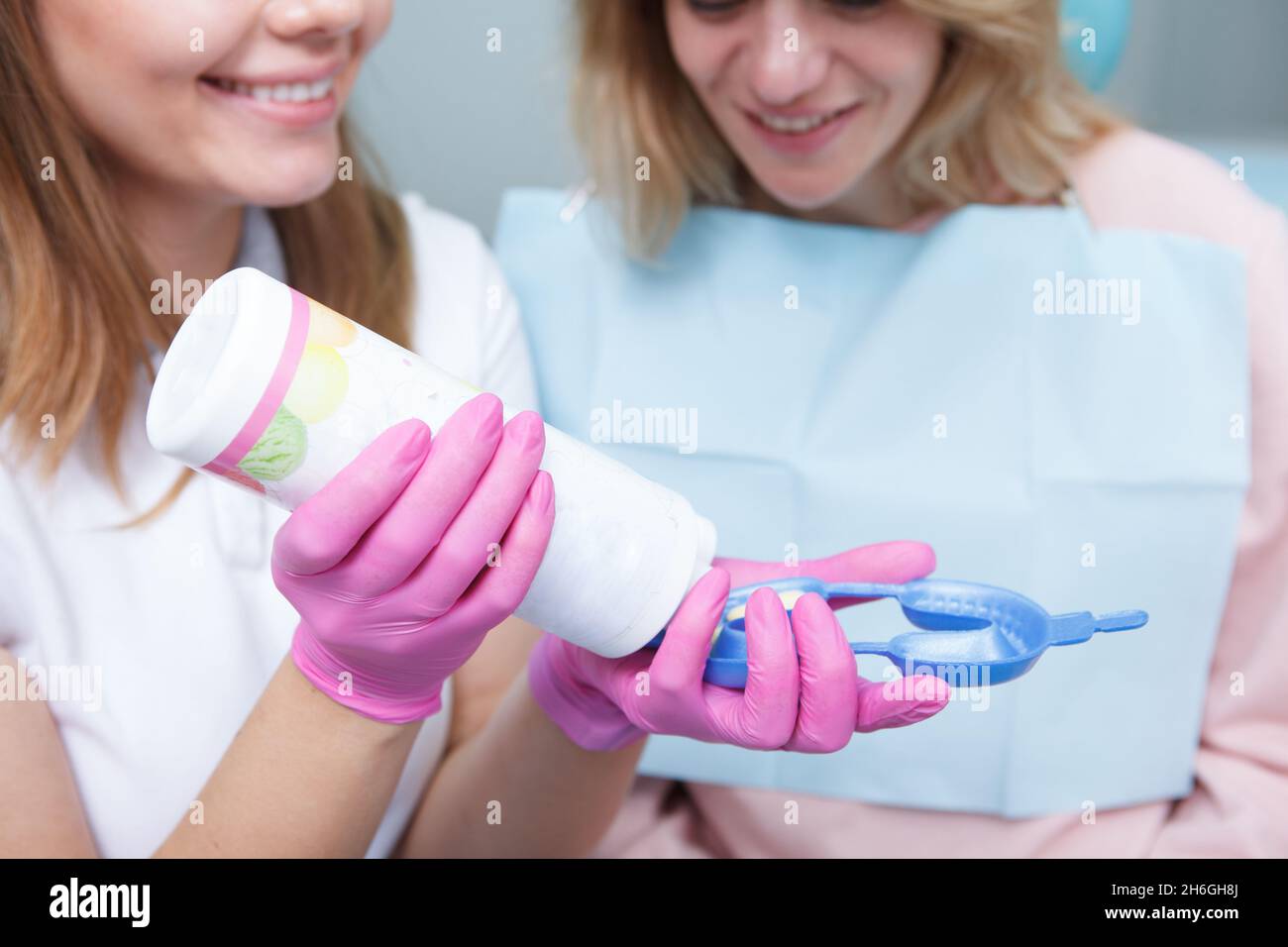 Dentist filling dental mold with dental gel for her mature female patient Stock Photo
