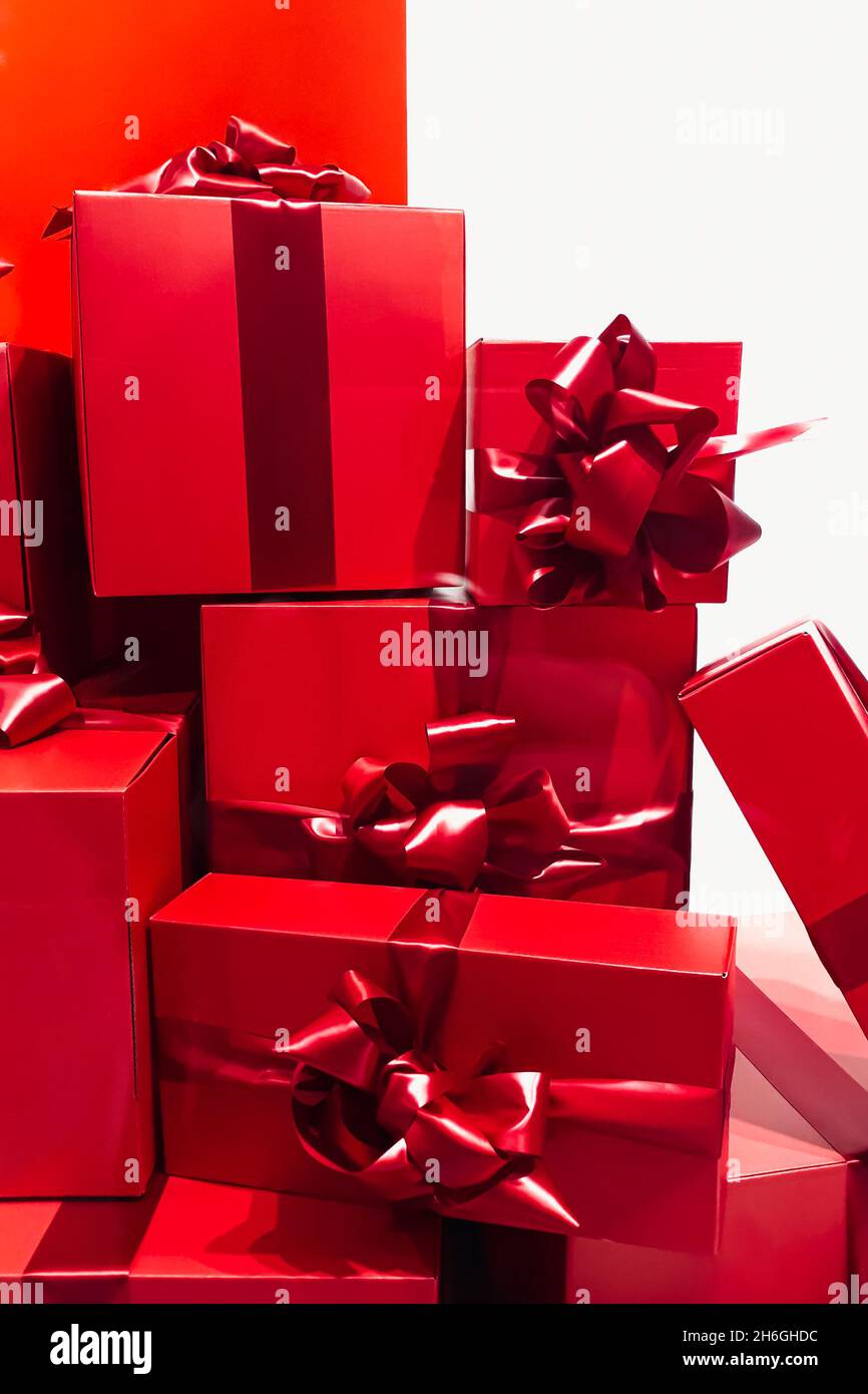 Large pile of Christmas gifts. Many red gift boxes with bows on white