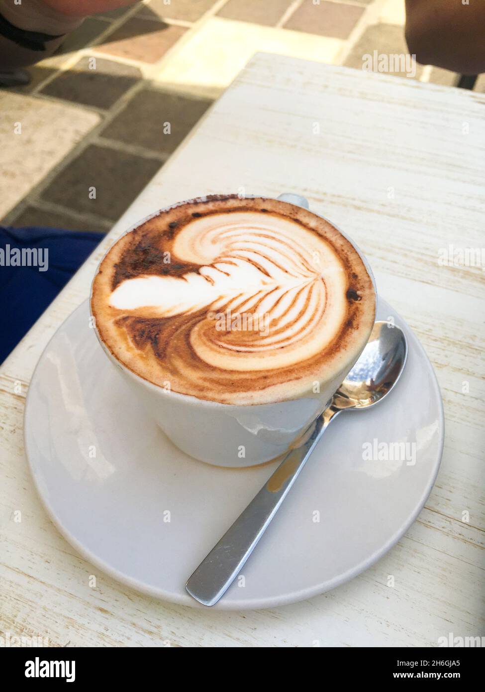 Tasse Cappuccino mit Kakao verziertem Milchschaum Stock Photo