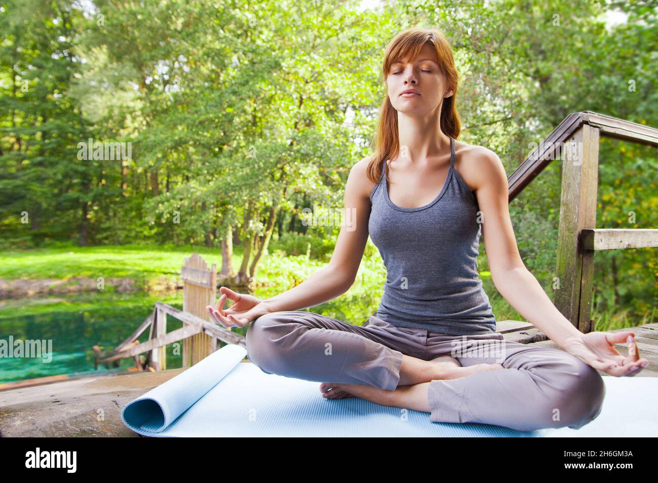 Young girl doing yoga lotus pose in the park Stock Photo - Alamy