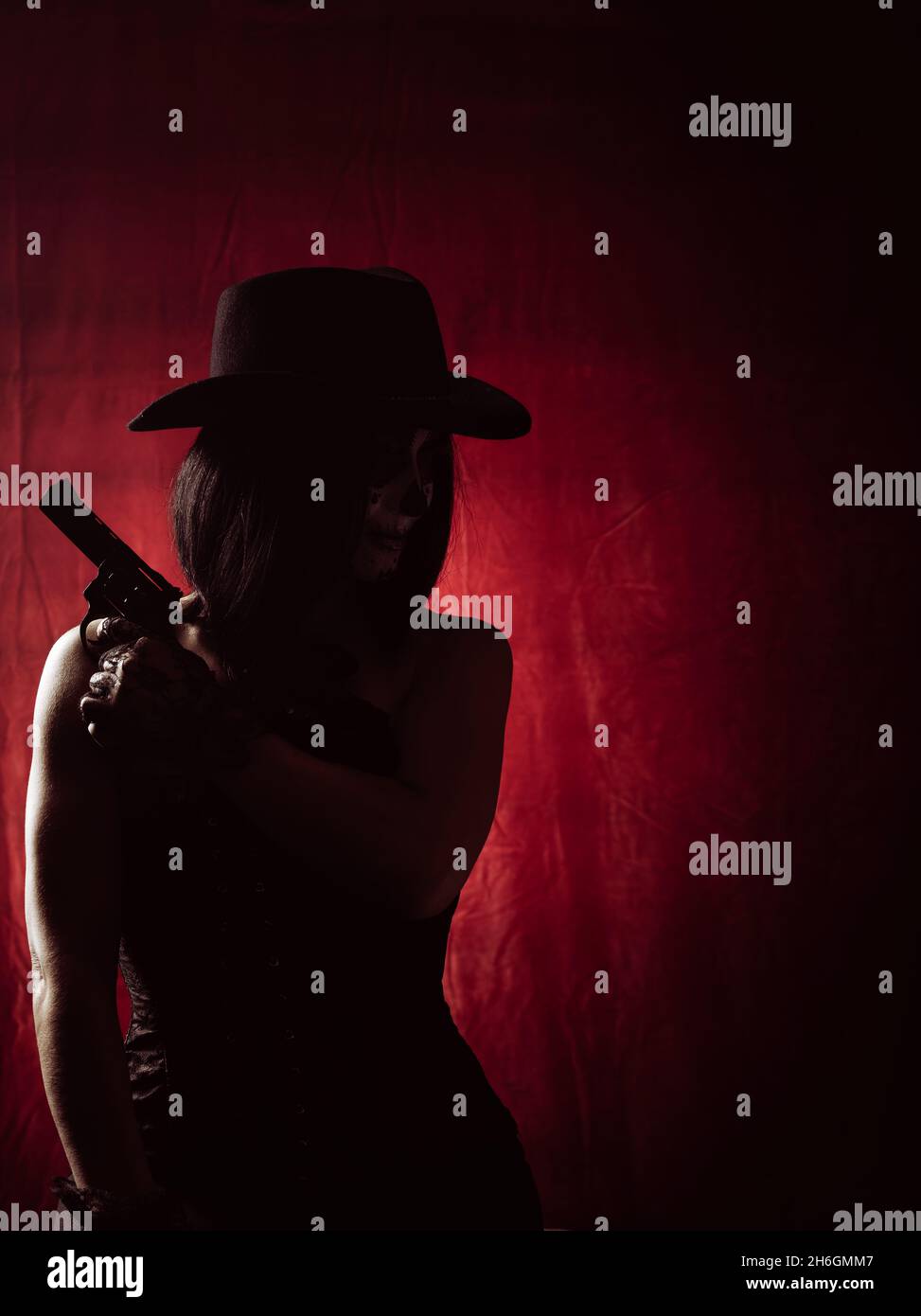 Red Revolver Woman woman in corset and black hat holding revolver on red background ...