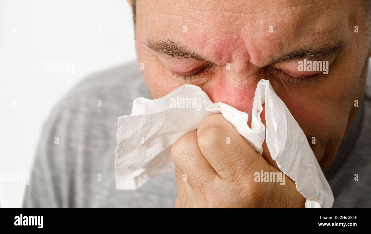 A man has a cold and blows his nose into a handkerchief Stock Photo Alamy