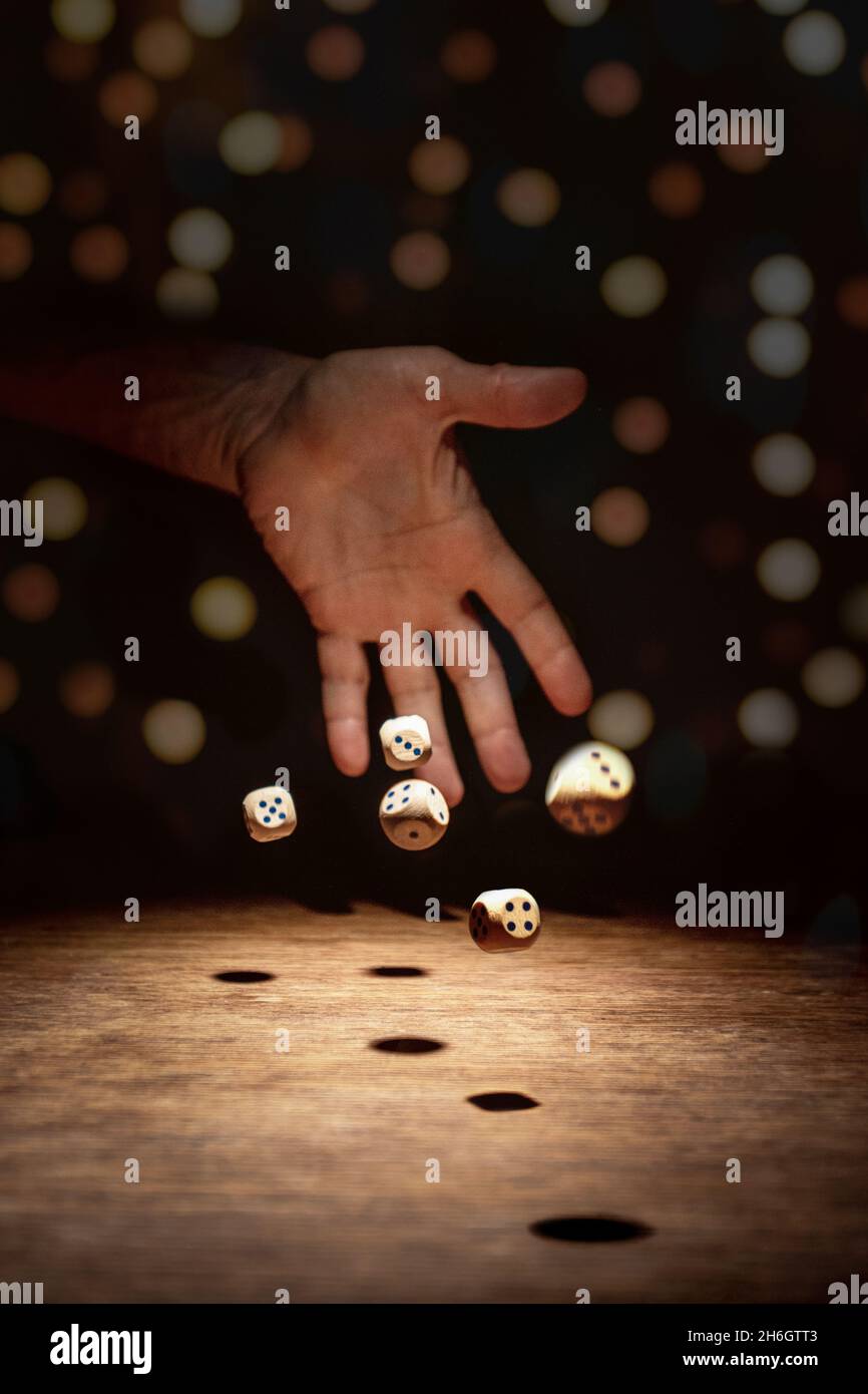 the dice thrown by the hand are scattered Stock Photo