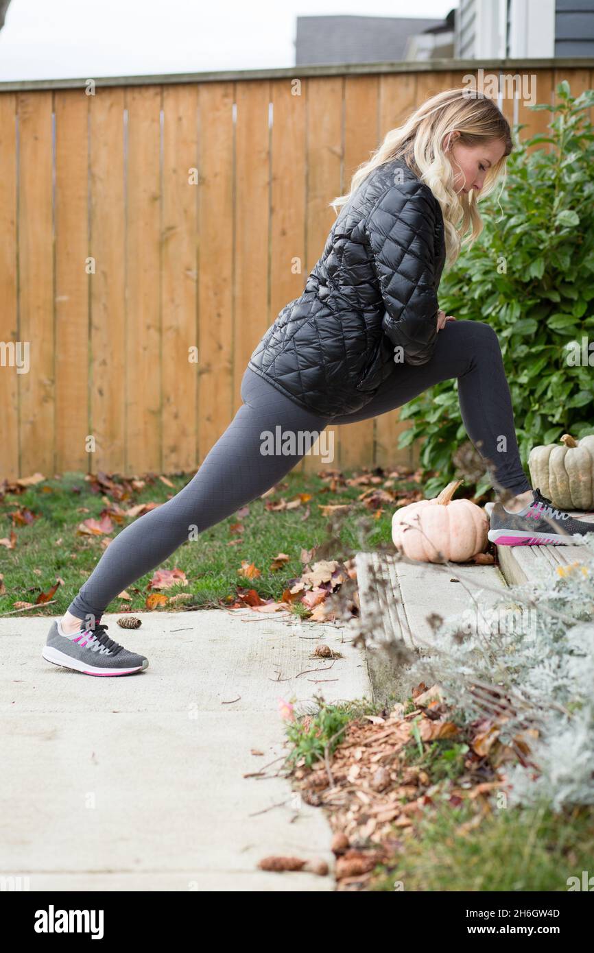 Woman stretches calves on front porch Stock Photo Alamy