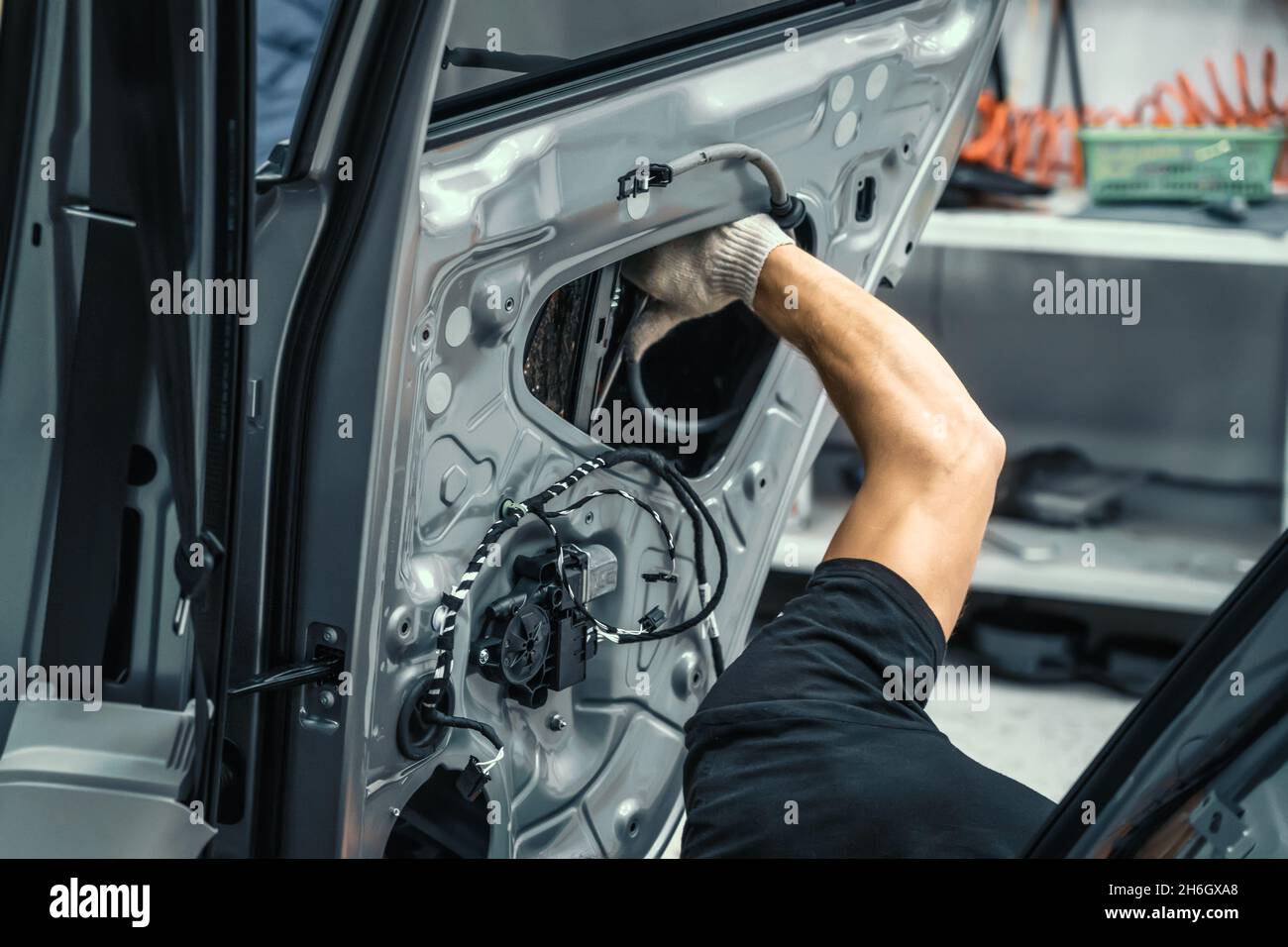 Auto service worker disassembles car door for repair, restoration