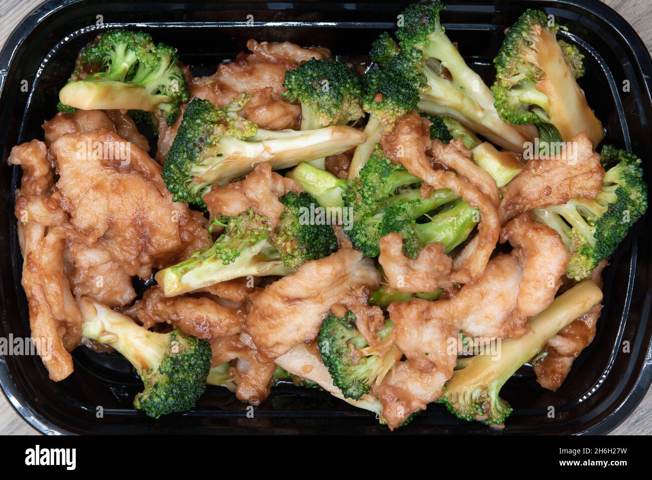 Overhead view of delicious bowl of broccoli and chicken blended for a specially seasoned Chinese fast food meal. Stock Photo
