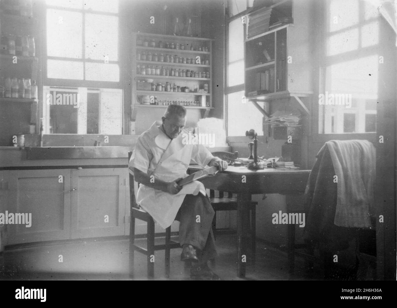 A pharmacist working at his chemist shop in Petrie Terrace, Brisbane, Queensland, Australia, 1950s. From the McKechnie family collection. Stock Photo