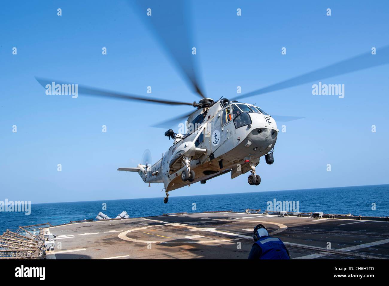 210906-N-JW440-2062 ARABIAN SEA (Sept. 6, 2021) A Pakistan Navy SH-3 Sea King helicopter lands on the flight deck of the guided-missile cruiser USS Shiloh (CG 67) during a passing exercise (PASSEX) with Pakistan Navy frigate PNS Alamgir (F 260) in the Arabian Sea, Sept. 6. Shiloh is deployed to the U.S. 5th Fleet area of operations in support of naval operations to ensure maritime stability and security in the Central Region, connecting the Mediterranean and the Pacific through the western Indian Ocean and three strategic choke points. (U.S. Navy photo by Mass Communication Specialist 1st Clas Stock Photo