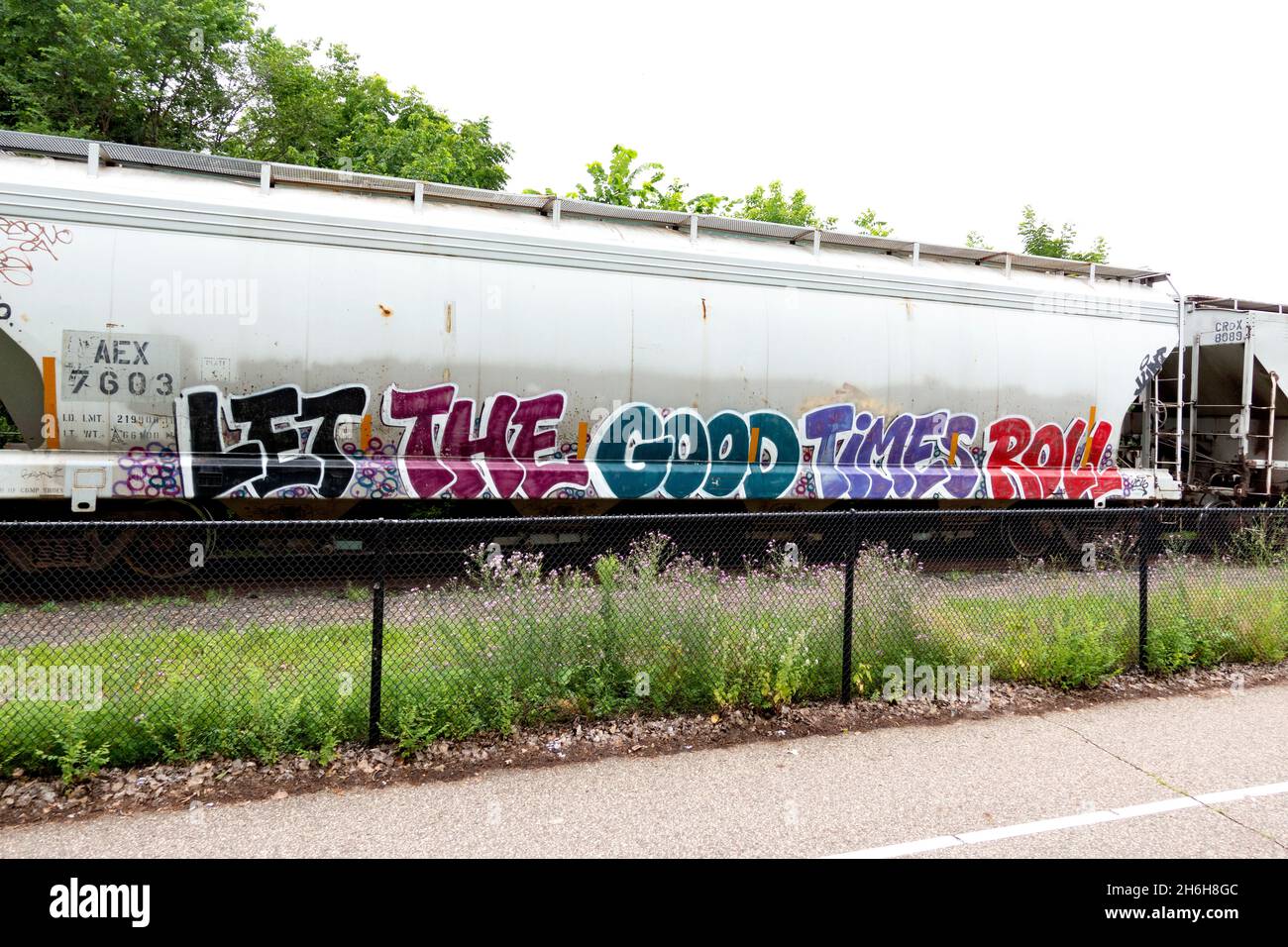 Minnesota Commercial Railroad transport car beside the Midtown Greenway trail with graffiti 'Let the good times roll'. Minneapolis Minnesota MN USA Stock Photo