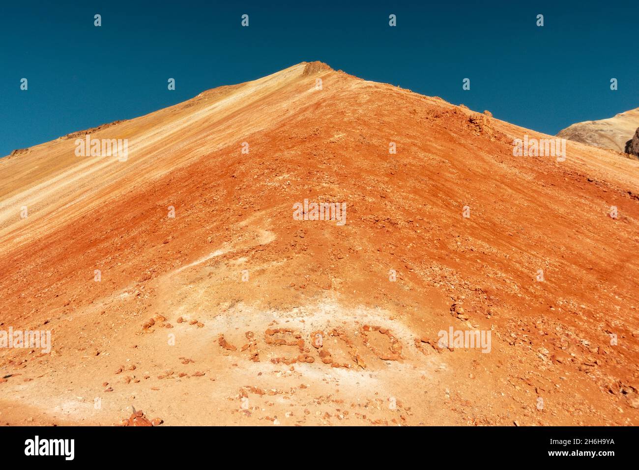 volcanic Bolivian landscape with stone sign of 4900 meters at the bottom of the slope Stock Photo