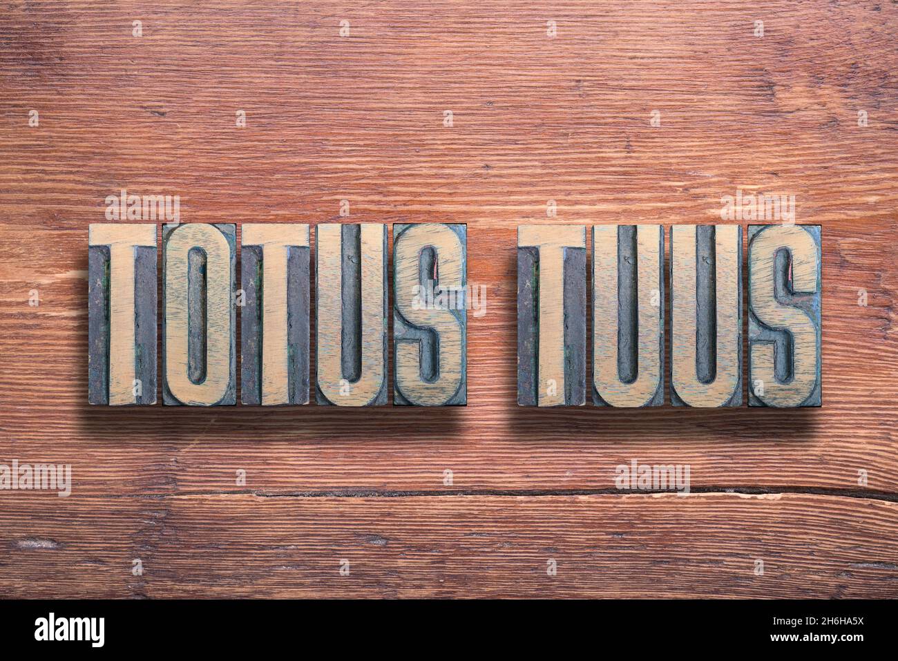 Totus Tuus ancient Latin saying meaning - Totally yours, combined on vintage varnished wooden surface Stock Photo