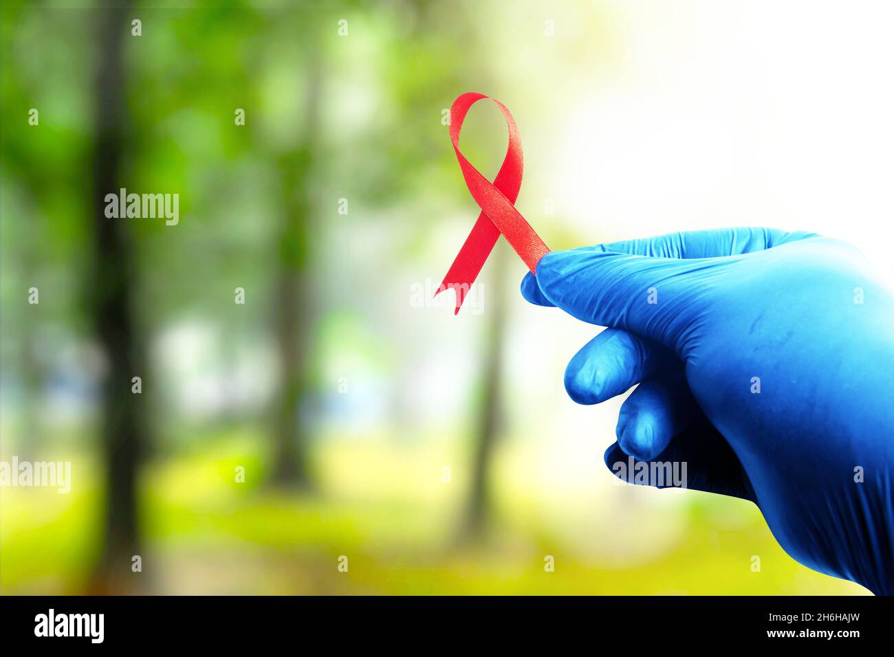 Red ribbon and medical glove with a bright background. Hiv Aids ribbon ...