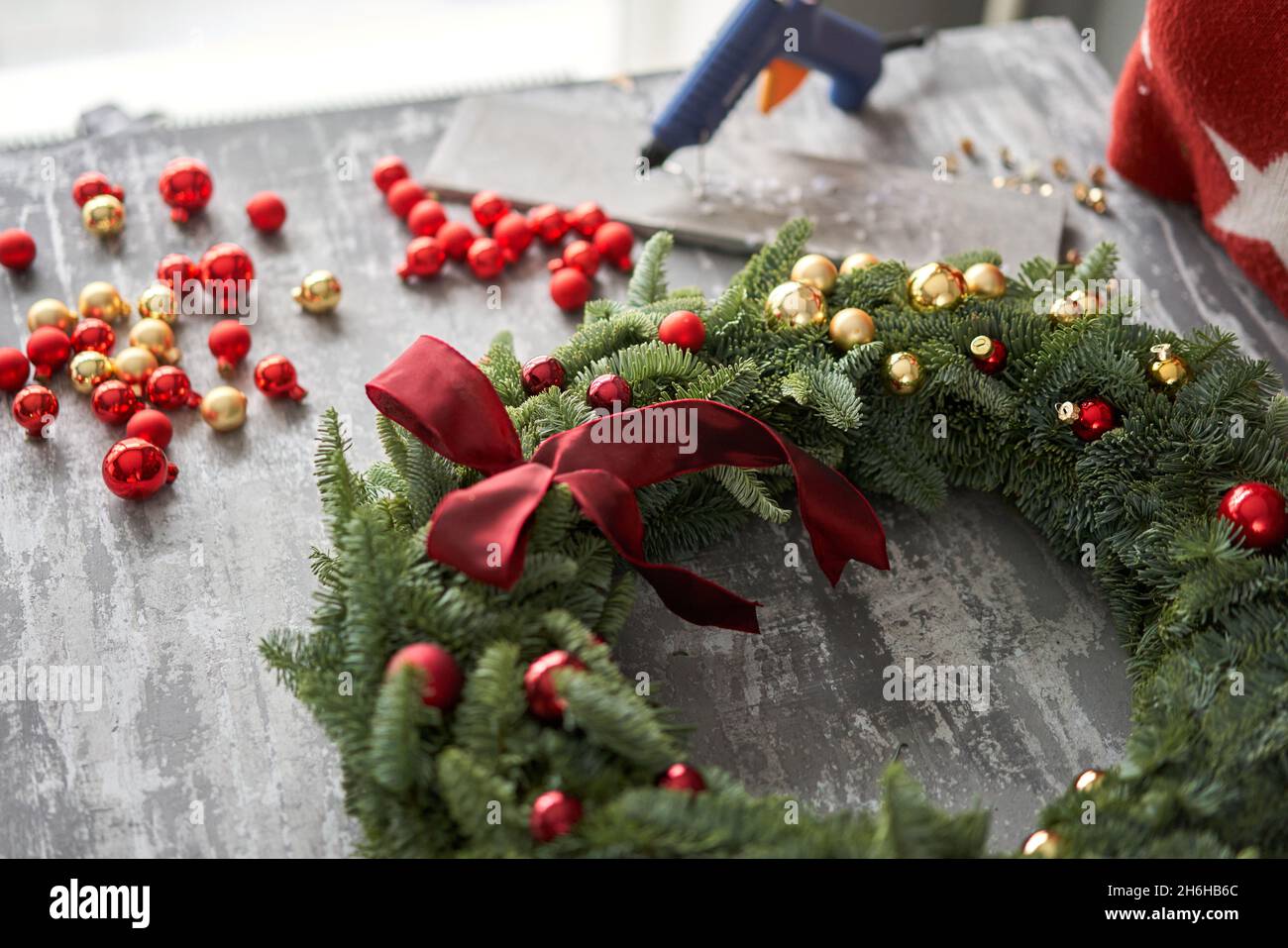Manufacturer of Christmas wreath from branches of pine for holiday. Master class on making decorative ornaments. Christmas decor with their own hands. Stock Photo