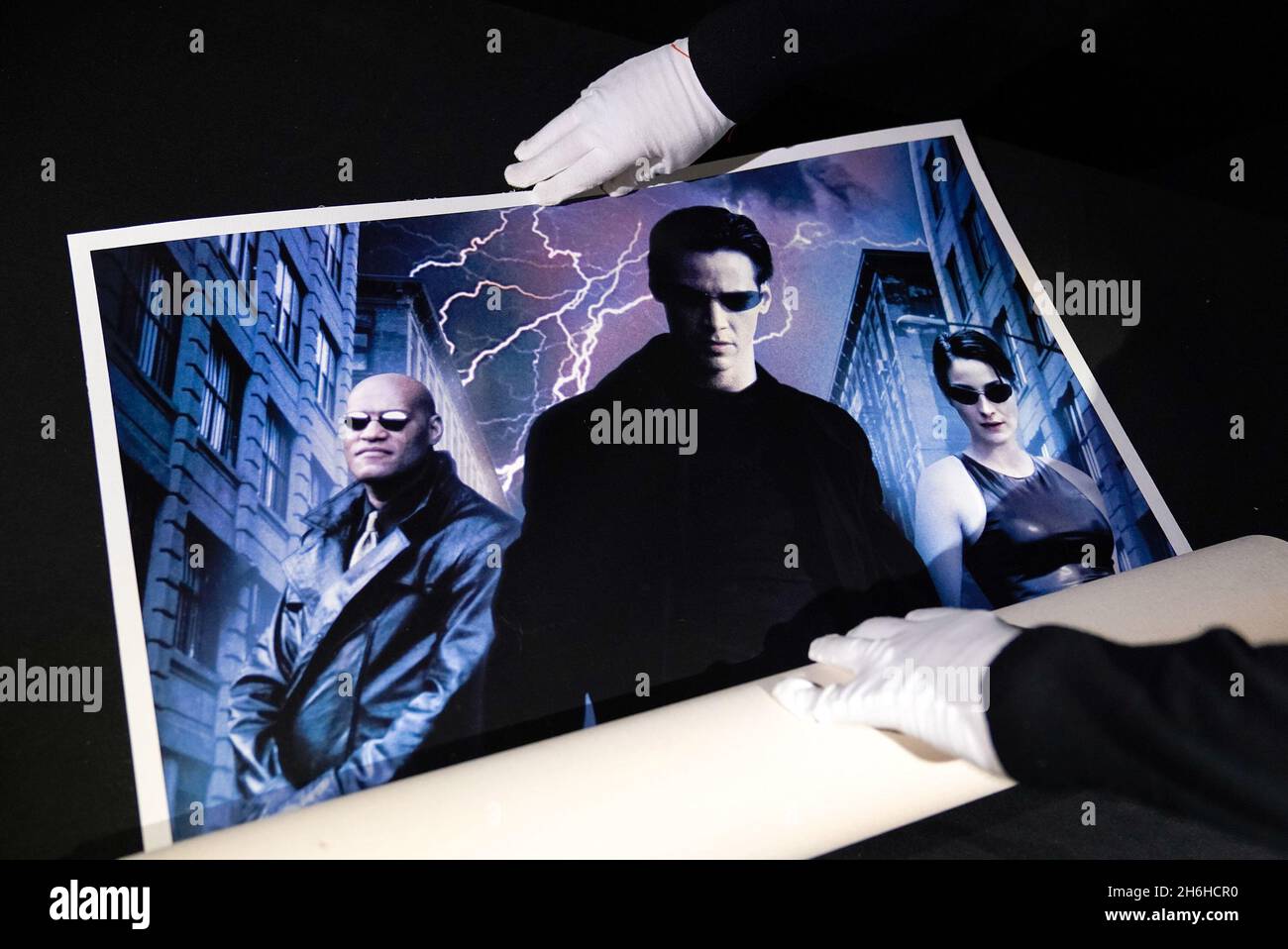 Prop Store poster consultant Mark Hochman unrolls an international One-Sheet 'Lightning Strike' style poster from the 1999 film 'The Matrix' at their auction house in Rickmansworth, Hertfordshire. It is estimated to sell between £4,000 - £6,000 in the forthcoming cinema poster auction by the Prop Store. Picture date: Thursday November 4, 2021. Stock Photo
